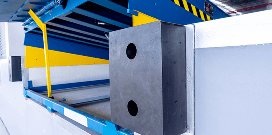 Close-up of industrial machine safety guard and metal block inside a manufacturing facility.